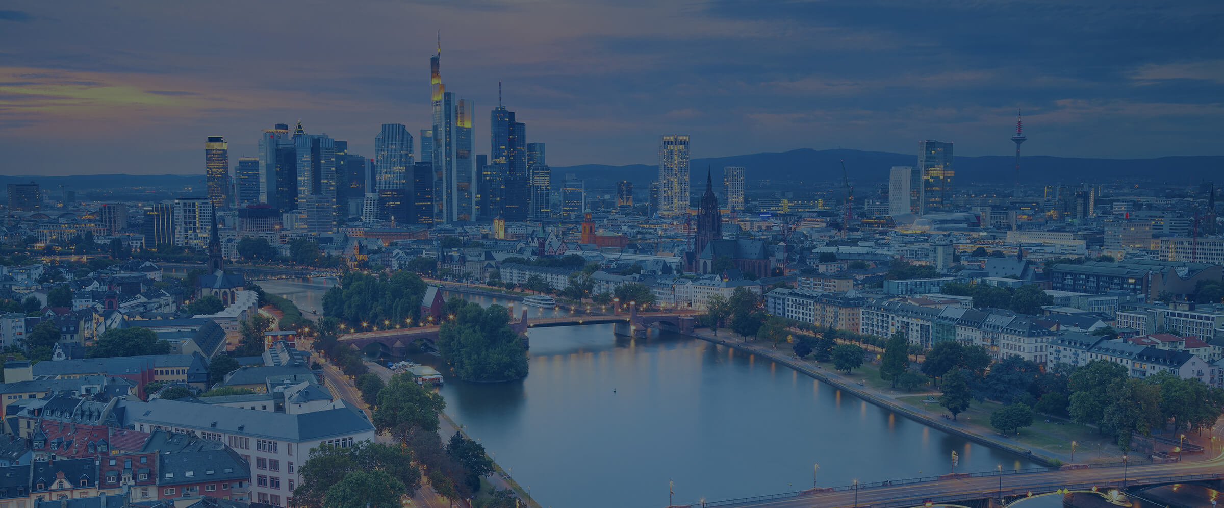 Frankfurter Skyline mit Bankent&uuml;rmen und Main im Abendlicht