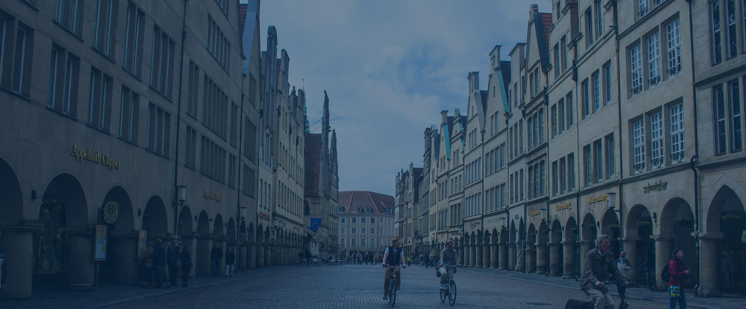 Prinzipalmarkt in M&uuml;nster mit Fahrradfahrern und Giebelh&auml;usern